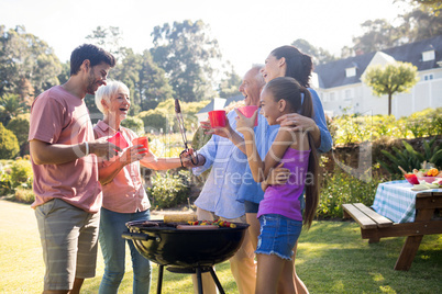 Family laughing and talking while preparing barbecue in the park