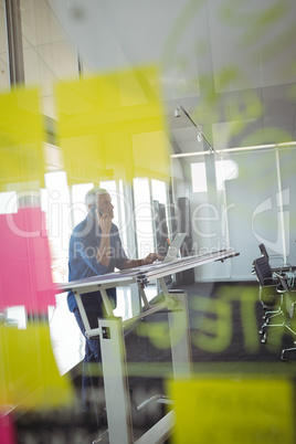 Mature businessman seen through glass in office