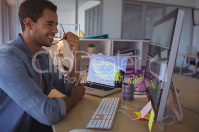 Smiling businessman looking at computer in office
