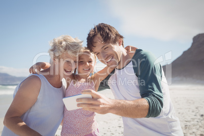 Happy multi-generated family taking selfie at beach