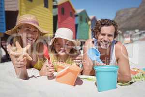 Portrait of happy family lying on blanket at beach