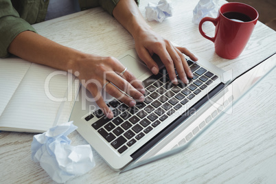 Businesswoman using laptop on desk in office