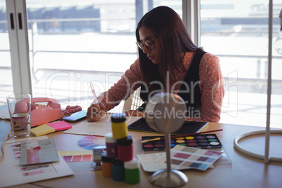 businesswoman writing on paper at creative office