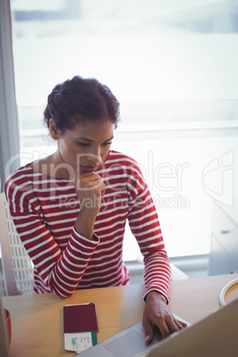 Serious businesswoman using laptop in office