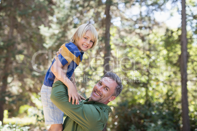 Portrait of playful father lifting up son