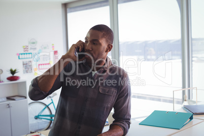 Serious businessman talking on phone in office