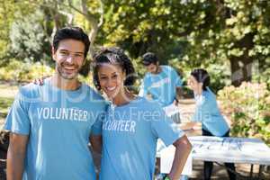 Smiling volunteers standing in the park