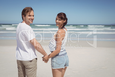 Portrait of young couple holding hands at beach