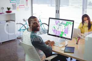 Smiling male designer working in creative office