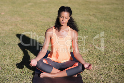 Woman practicing lotus position on mat