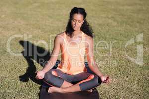 Woman practicing lotus position on mat