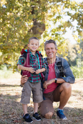 Portrait of happy boy and father in forest