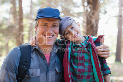 Portrait of happy father and son with arm around