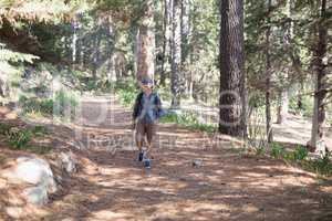 Happy hiker walking trail amidst trees