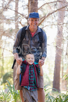 Portrait of playful father and son in forest