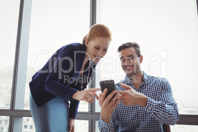 Smiling executives using mobile phone