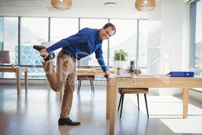 Smiling executive exercising in office