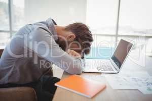 Tired executive leaning on desk