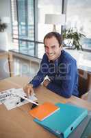 Portrait of smiling executive using digital tablet at desk