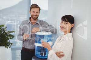 Portrait of smiling executives holding glasses of water