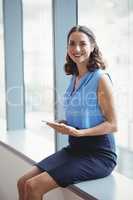 Portrait of smiling executive holding digital tablet