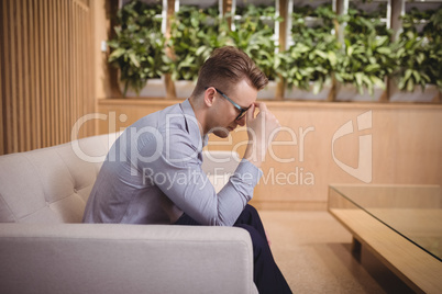 Tensed executive sitting on sofa