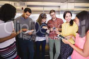 Smiling business people discussing in elevator