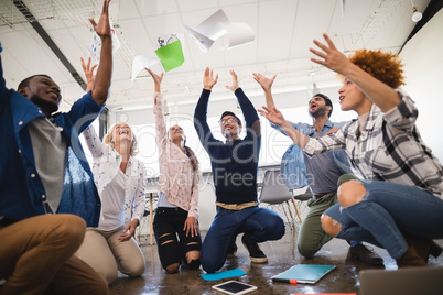Cheerful business colleagues tossing papers