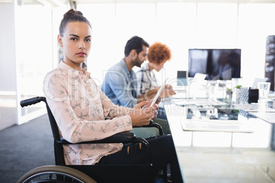 Portrait of businesswoman using digital tablet while sitting on wheelchair