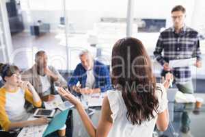 High angle view of businesswoman discussing with team