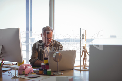 Focused businessman working on laptop at office