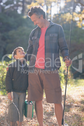 Father and son looking at each other with fishing equipment
