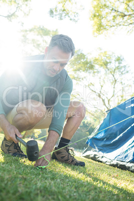 Man setting up the tent at campsite