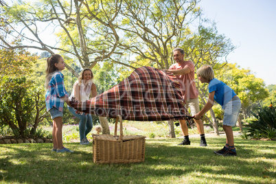 Family spreading the picnic blanket