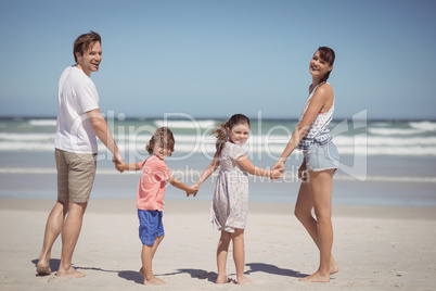 Portrait of happy family holding hands at beach