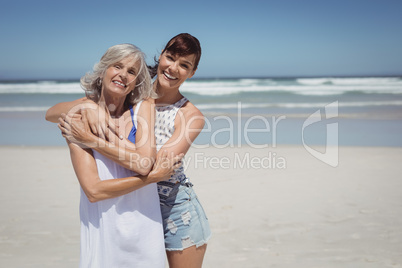 Portrait of happy woman with her mother standing at beach