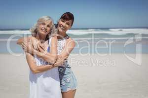 Portrait of happy woman with her mother standing at beach