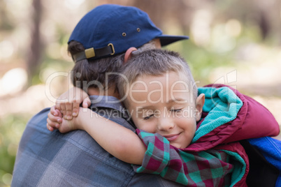 Father and son embracing in forest