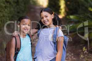 Smiling friends standing at natural parkland