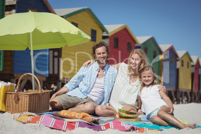 Portrait of fappy family sitting on blanket at beach