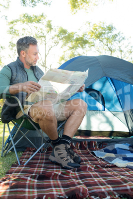 Man reading the map outside the tent