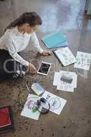 Businesswoman with digital table working on floor