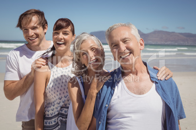 Portrait of happy family standing in row at beach