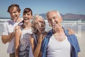 Portrait of happy family standing in row at beach