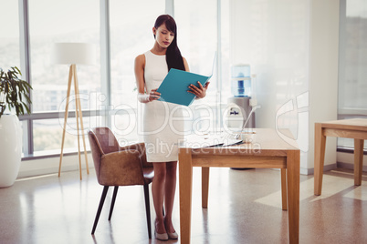 Attentive executive reading file at desk