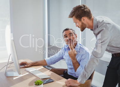 Executives interacting while working at desk