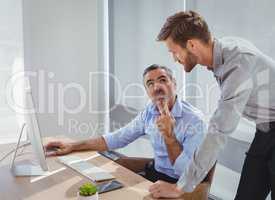 Executives interacting while working at desk