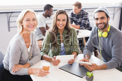 Portrait of smiling business people sitting at table
