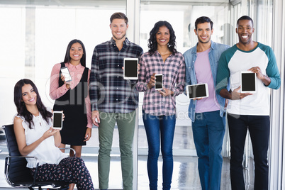 Portrait of creative business team holding tablet pc and mobile phones