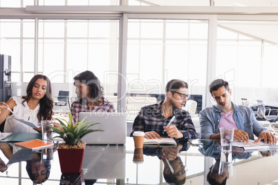 Creative business colleagues working at glass table